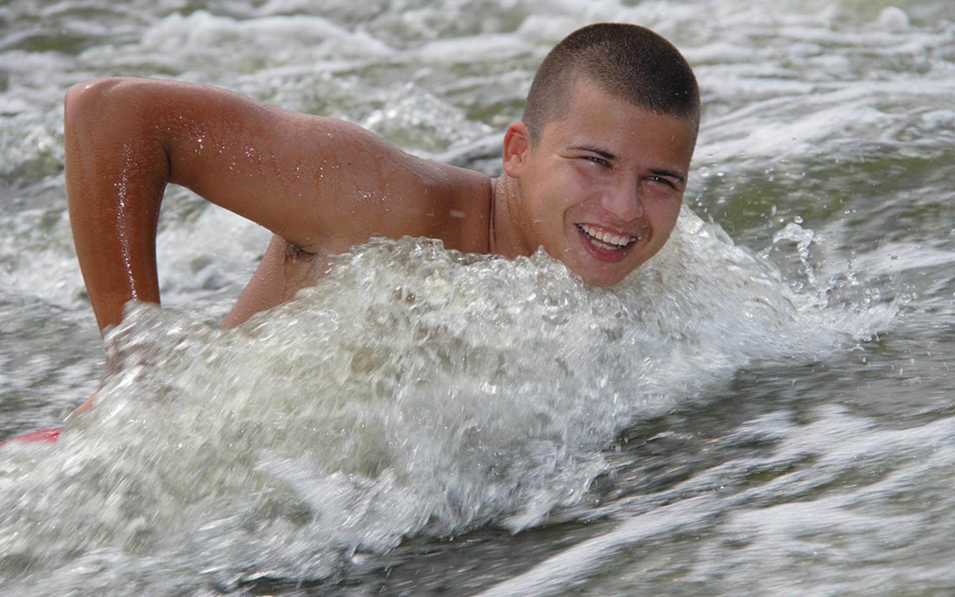 Junger Mann schwimmt gegen den Strom.