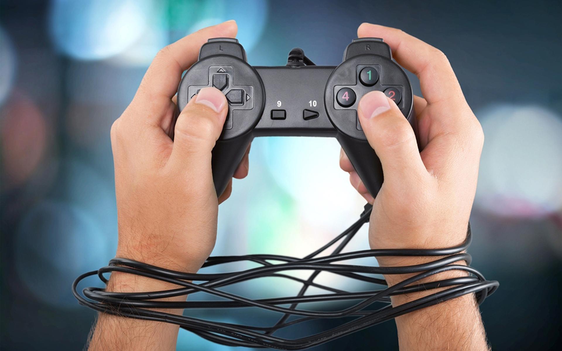Hände gefesselt mit Kabel von Playstation-Konsole