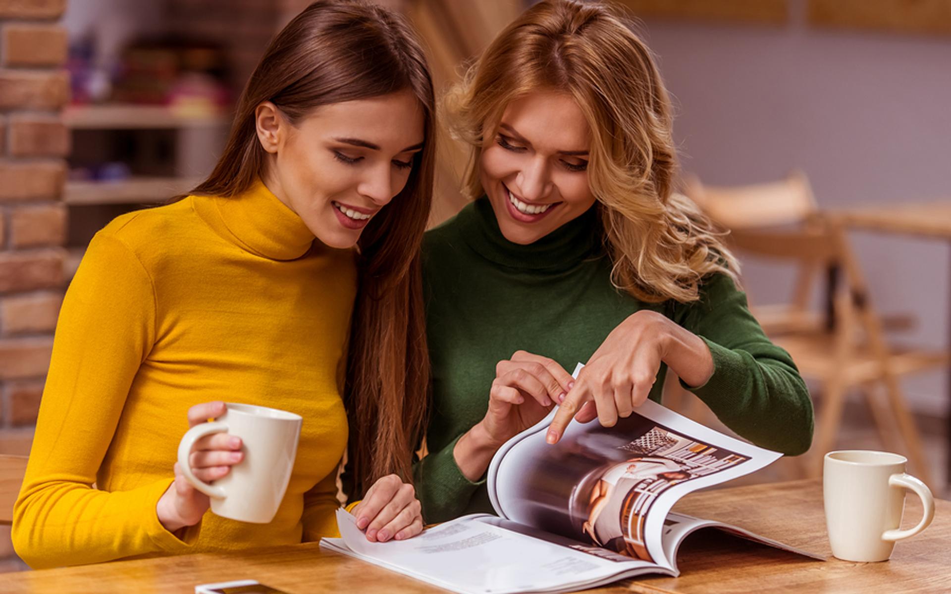 Zwei Frauen schauen einen Katalog an.