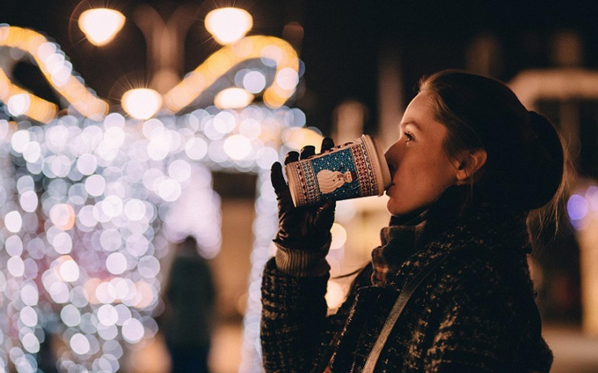Junge Frau mit Kaffeebecher in der Hand