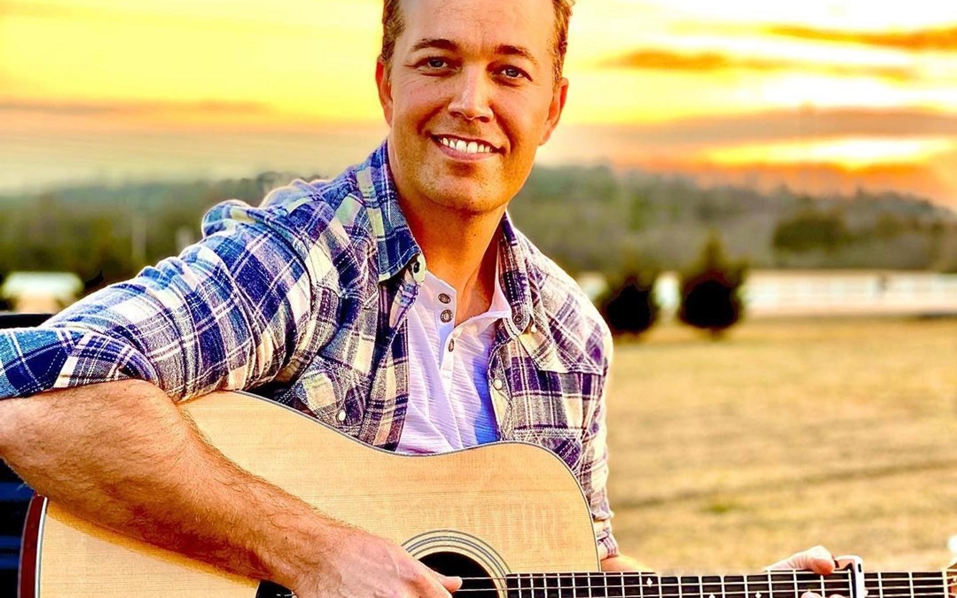 Lucas Hoge mit seiner Gitarre und dem Sonnenuntergang