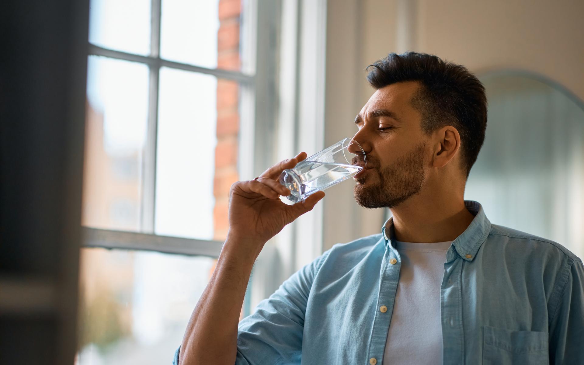 Durstiger Mann trinkt ein Glas Wasser