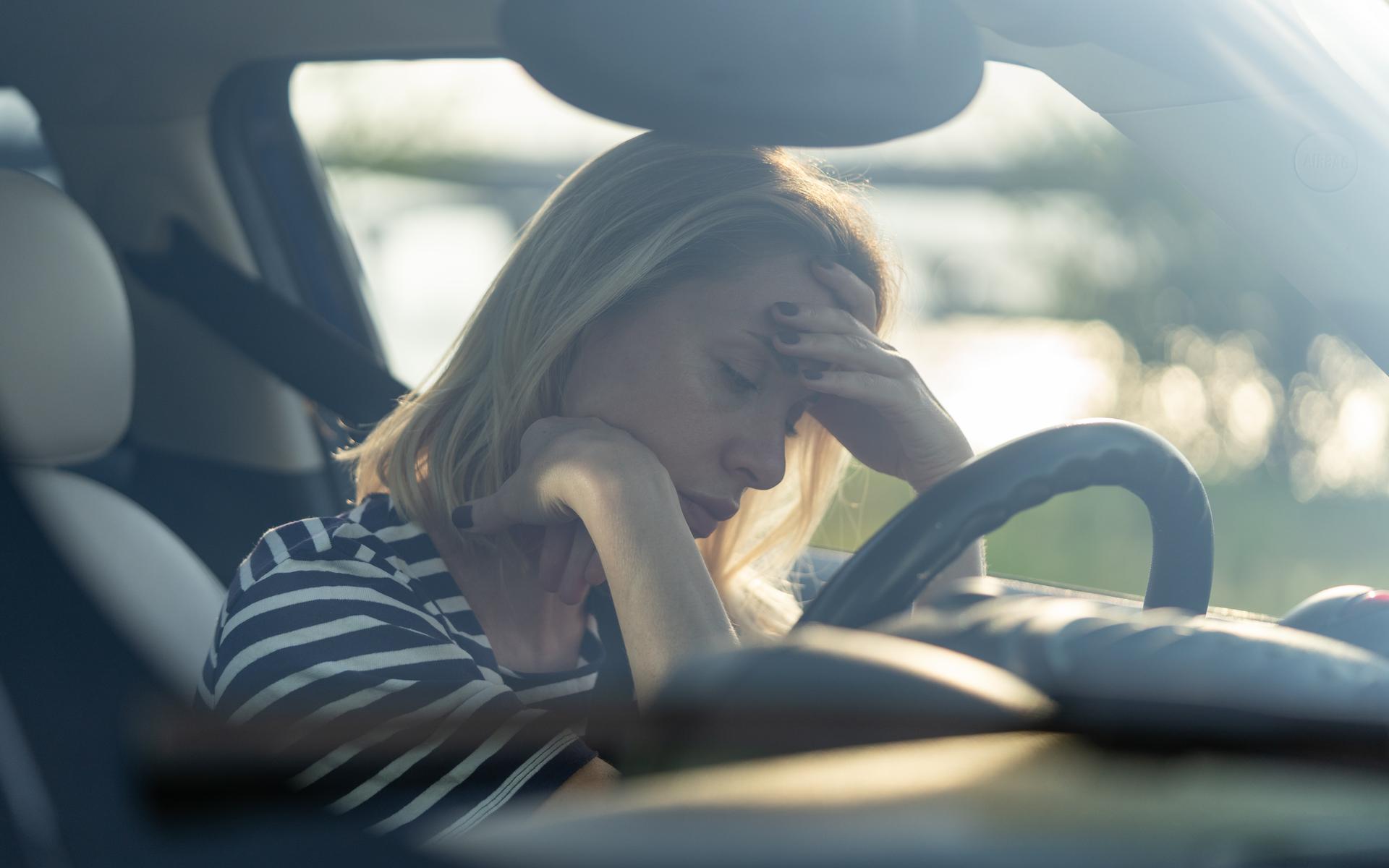 Frau sitzt verzweifelt im Auto