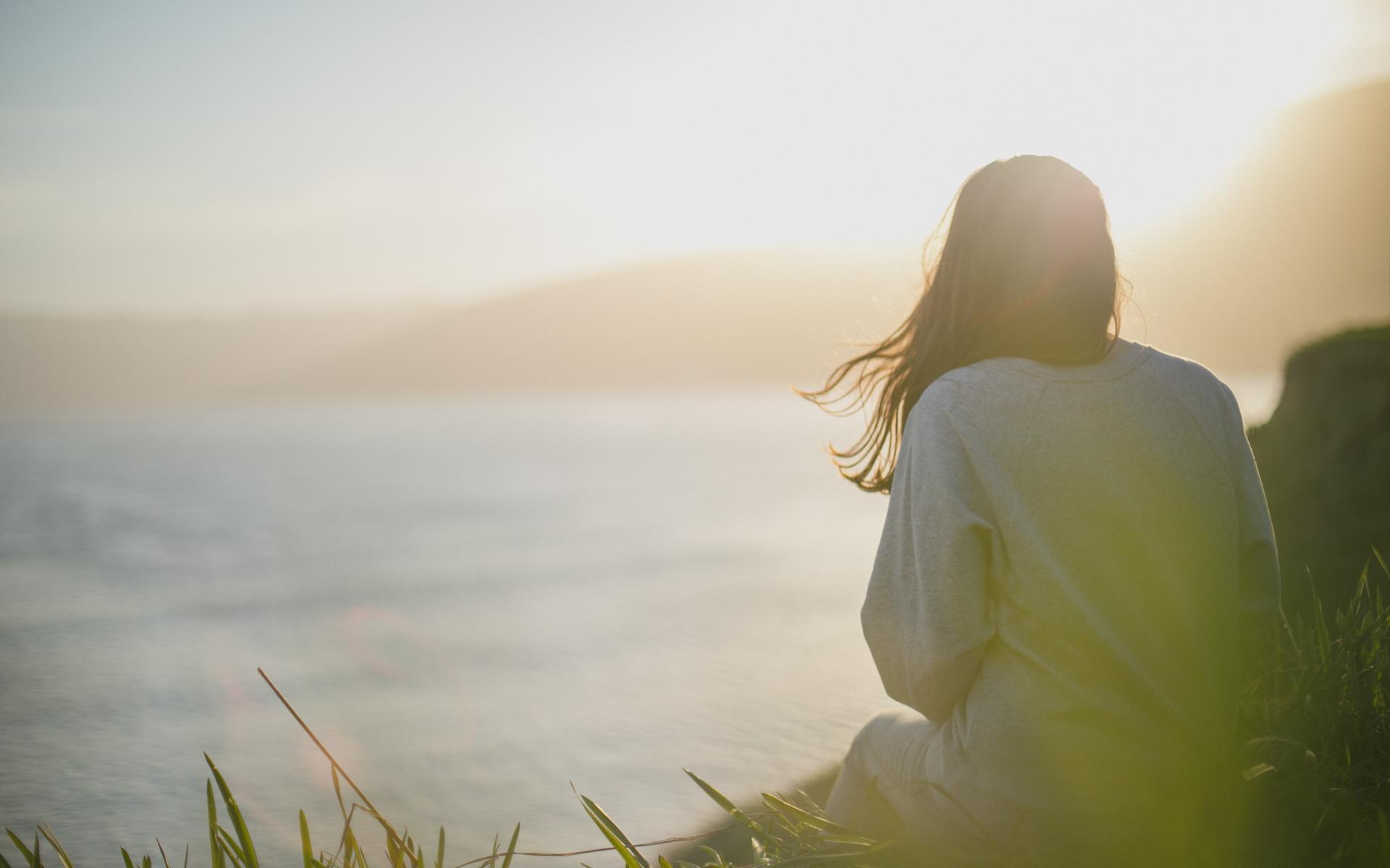 Junge Frau sieht aufs Meer hinaus