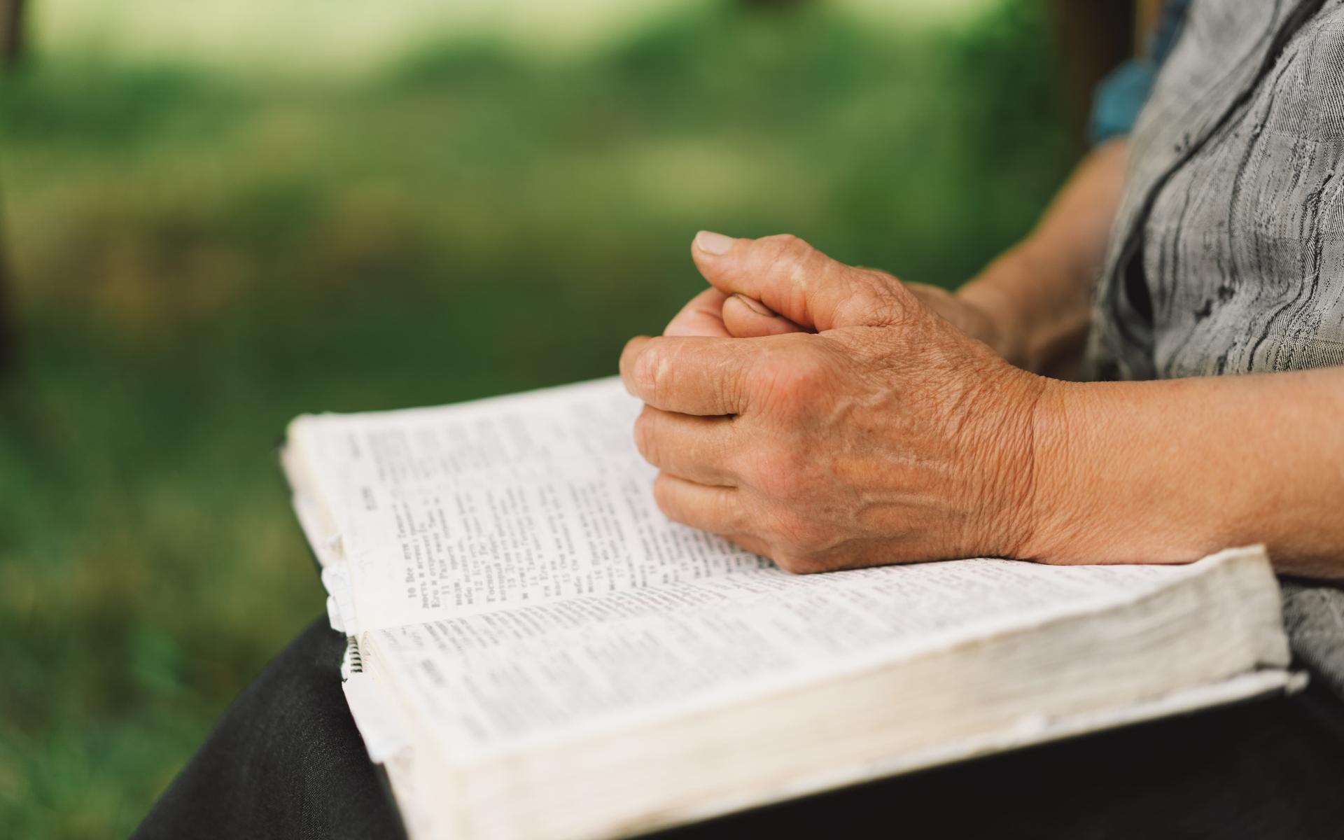 Eine alte Frau liest die Bibel (Symbolbild)