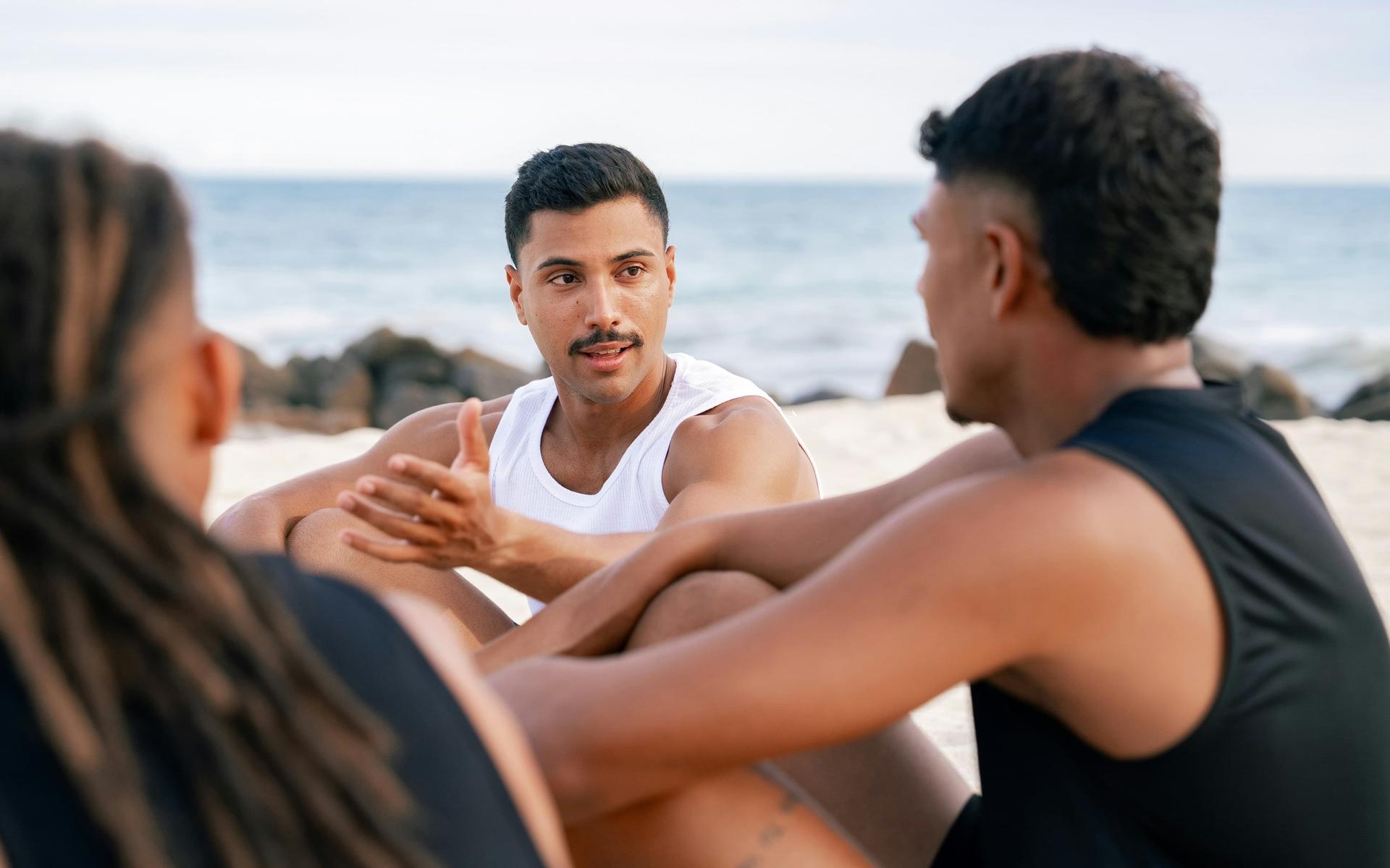 zwei-manner-und-eine-frau-sitzen-am-strand