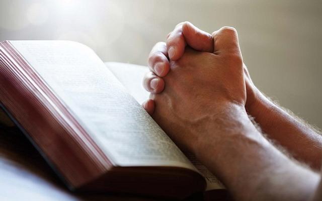 betende Hände auf Bibel
