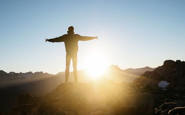 Mann auf Berg bei Sonnenaufgang