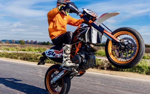 Ein Biker macht ein Wheelie