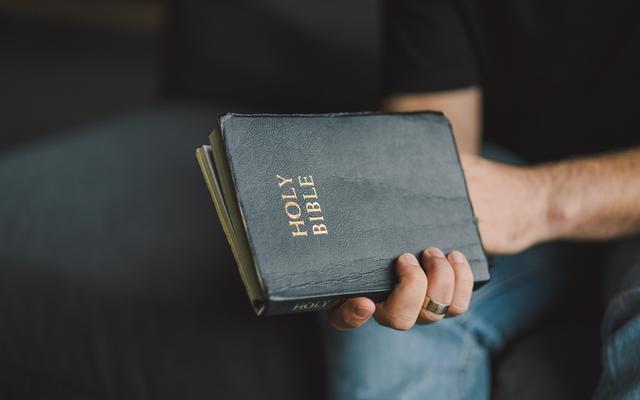 Mann hält Bibel