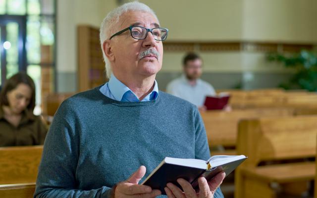 Älterer Mann hört einer Predigt zu