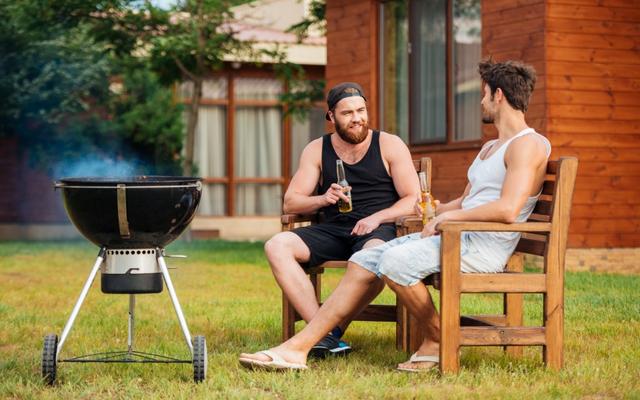Zwei Männer pflegen die Freundschaft beim Grillieren.