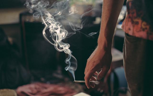Mann, der einen Joint hält