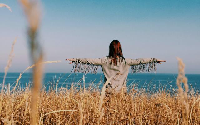 person-im-feld-vor-meer